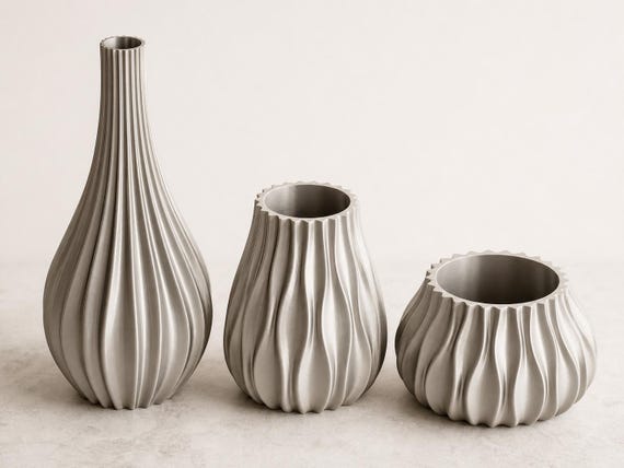 Close-up lineup of the PulsePetal vase, high planter, and low planter in Silk Silver