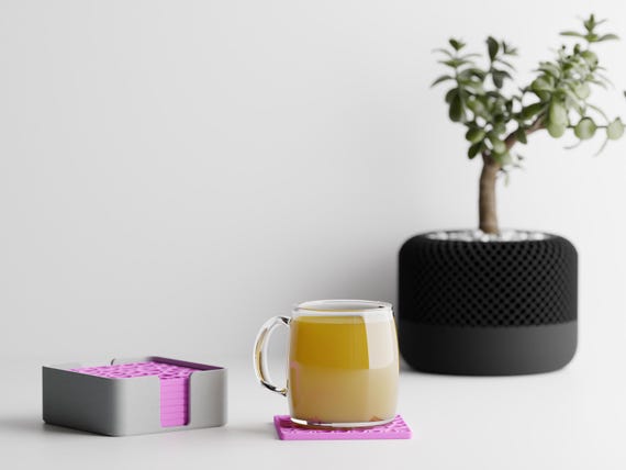 Close-up lifestyle view of the CanopyLace coaster set supporting a cup on a tabletop