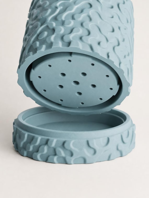 Close-up of the RippleGlyph planter drainage plate and matching Sky Blue drip tray