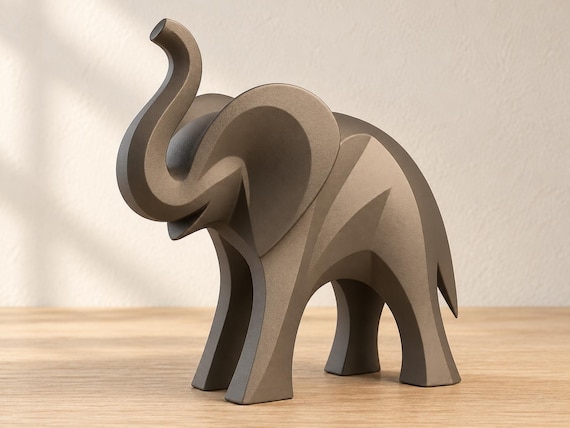 Warm taupe elephant sculpture, close-up main three-quarter view on pale oak against an ivory wall.