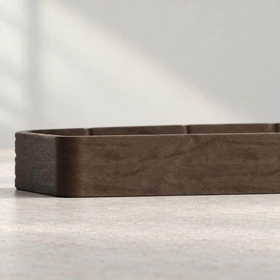 Low side close-up of the espresso brown Timberfold valet tray showing its shallow rim and wood grain texture on a light tabletop