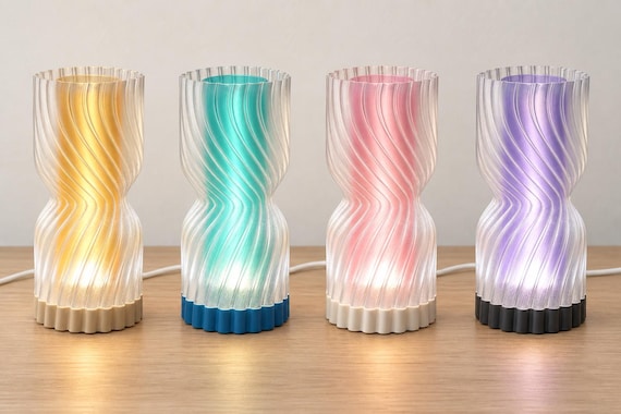 Four illuminated Rillora lamps with clear rippled outer shades, left to right: Amber Sand, Lagoon Mist, Blush Pearl and Lavender Night.