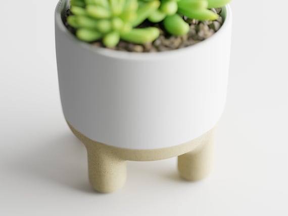 High-angle close-up of the CalmRise planter showing its smooth rounded pot and rim