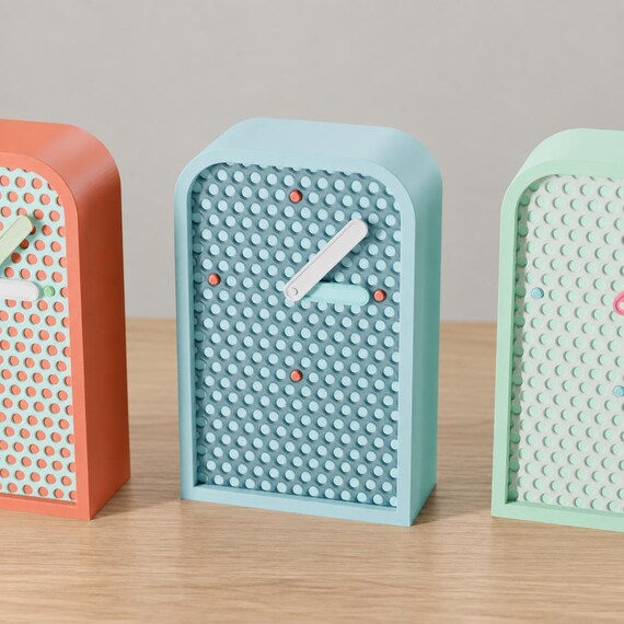 Latticehour Mesh Desk Clock blue example in a close front angled view on oak, with white and pale blue hands and coral hour markers.