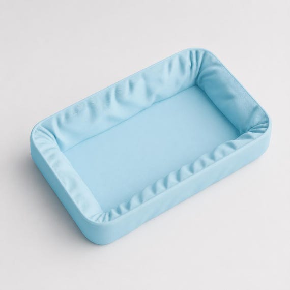 Empty Ice Blue DrapeVale vanity tray in a close-up view of its fabric-inspired sculpted details