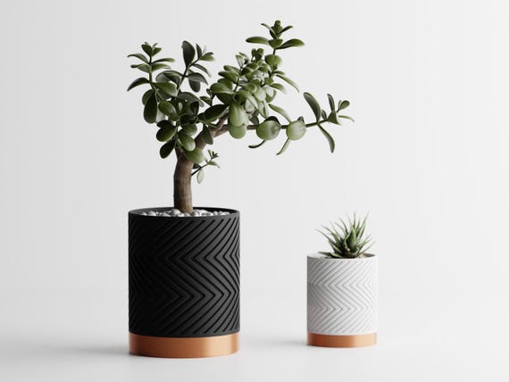 Close-up size comparison of two planted GleamRidge planters in Copper Noir
