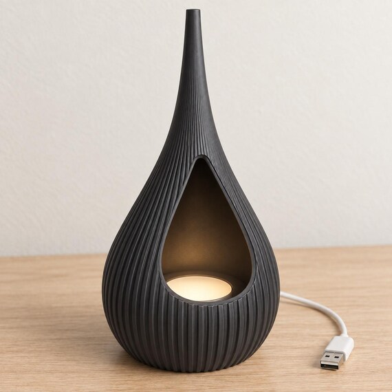 Charcoal Solenne holder with a warm flat LED light inside and a white USB cable on a pale wood tabletop.