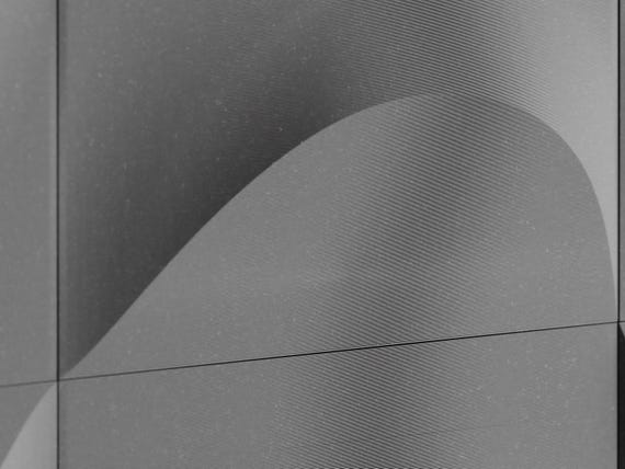Macro close-up of the charcoal TideFold relief surface and smooth flowing crest