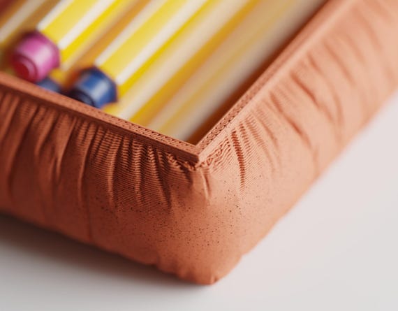 Close-up of the GatherFold accessory tray showing its gathered fabric-look texture