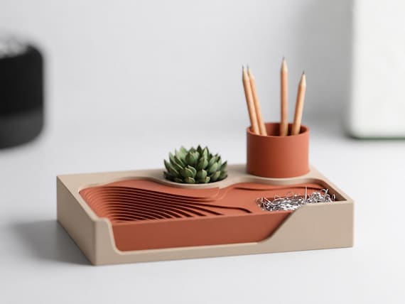 TerraceHub organizer with Desert Tan outer frame and Terracotta landscape and pen cup, front three-quarter desk view.