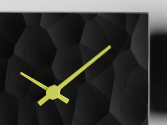 Close-up of Facetfield's Charcoal organic geometric relief and Lemon Yellow hands