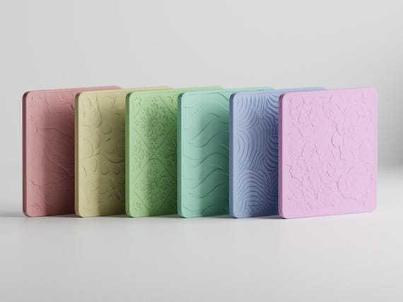 Angled close-up of all six TactileBloom square coasters showing their distinct raised patterns