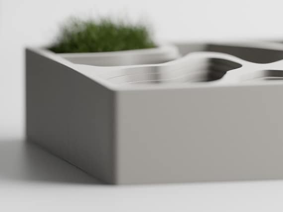 Left-side close-up of the ContourCove tray's fixed terraces and raised rectangular frame