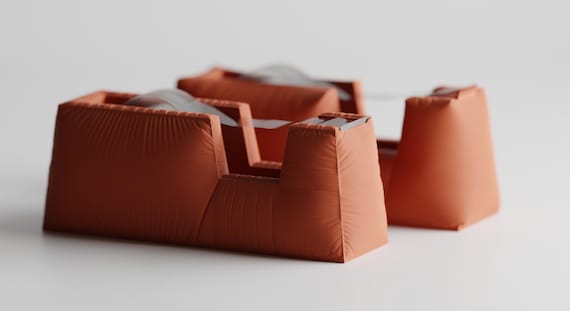 Sculptural fabric-look tape dispenser on a clean office surface