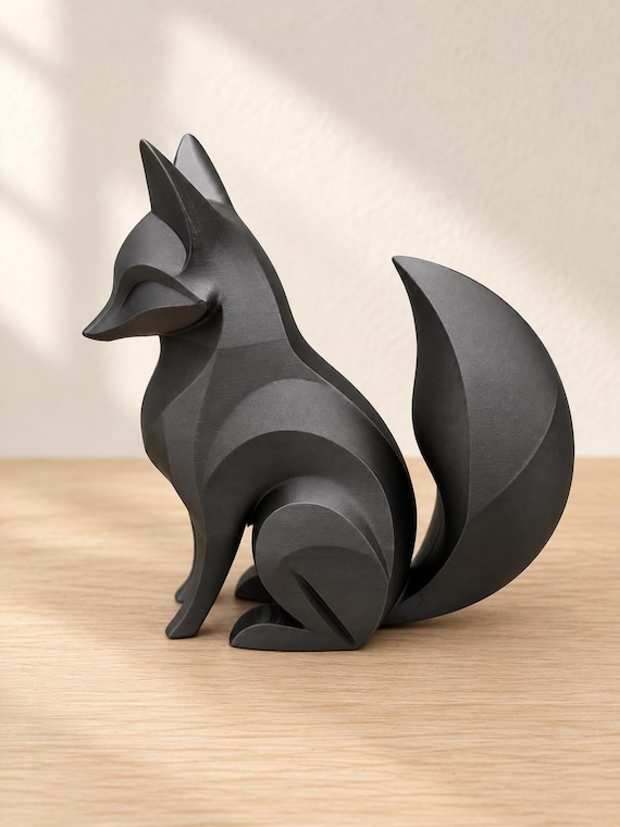 Charcoal fox sculpture, close-up alternate camera angle on pale oak against an ivory wall.