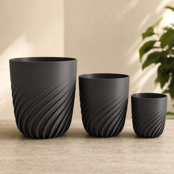 Close-up comparison of three complete Flowspire spiral rib planters in Charcoal