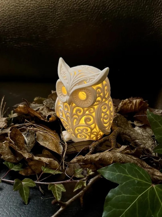 Close side view of the solid Ivory White owl lamp and raised wing relief