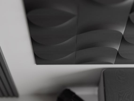 Angled close-up of charcoal TideFold wall tiles showing sculpted depth and shadow