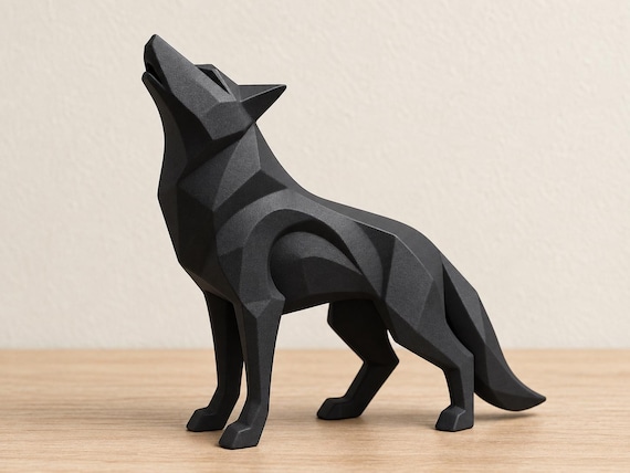Charcoal wolf sculpture, close-up main three-quarter view on pale oak against an ivory wall.