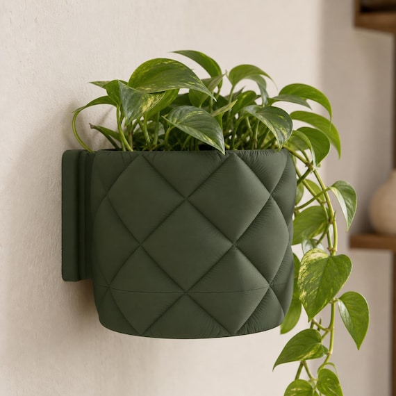 Close-up three-quarter view of a wall-mounted QuiltHaven planter with trailing pothos