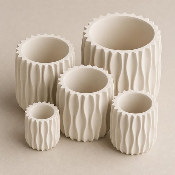 Close-up lineup of all five proportional WaveLoom planter sizes in Bone White