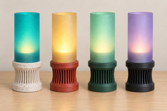 Four cordless Alvara lamps, left to right: Marble Tide, Granite Amber, Meadow Mist and Twilight Lilac, on a wood tabletop.