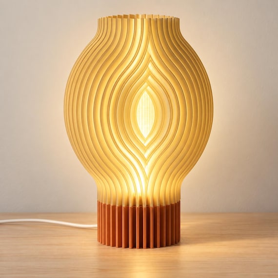 Sunlit Clay Veylora lamp with a Terracotta matte base and glowing Mellow Yellow ribbed shade on a pale wood tabletop, viewed from the front.