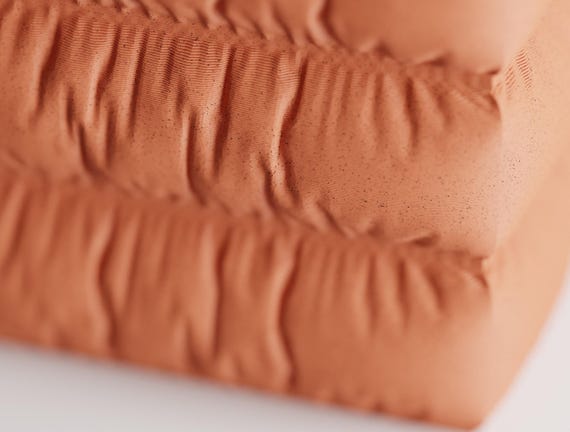 Close-up of the CushionCove pen holder showing its gathered fabric-look texture