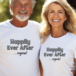 May include: A couple wearing white t-shirts with the text "Happily Ever After...again!" printed on them. They are smiling and standing close together.
