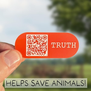 May include: An orange rectangular sticker with the word "TRUTH" and a QR code. The sticker is held in front of a blurred green background. Below the sticker is the text "HELPS SAVE ANIMALS!"
