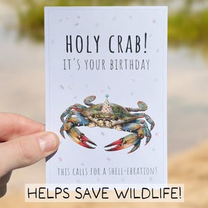 May include: A birthday card with a watercolor illustration of a crab wearing a party hat. The card reads "HOLY CRAB! IT'S YOUR BIRTHDAY" and "THIS CALLS FOR A SHELL-EBRATION!" with the text "HELPS SAVE WILDLIFE!" at the bottom.