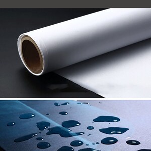 May include: A close-up of a white canvas roll, showing the texture of the material. Water droplets are shown on a similar canvas surface, demonstrating its water-resistant properties.
