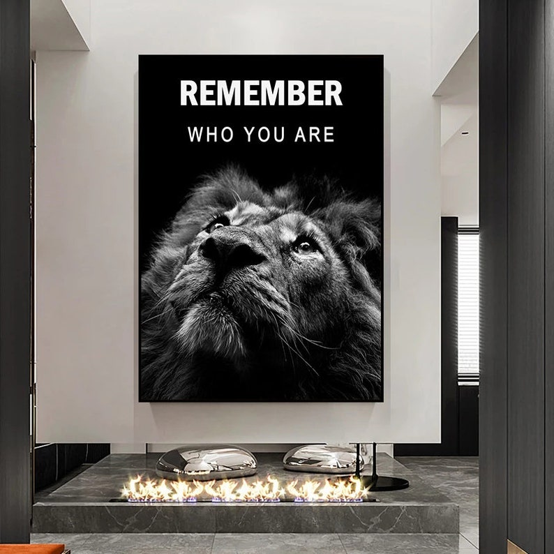 May include: Black and white motivational poster featuring a lion's face looking up with the text "REMEMBER WHO YOU ARE" in white.