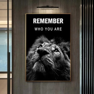 May include: Black and white motivational poster featuring a lion looking up with the text "REMEMBER WHO YOU ARE" in white.