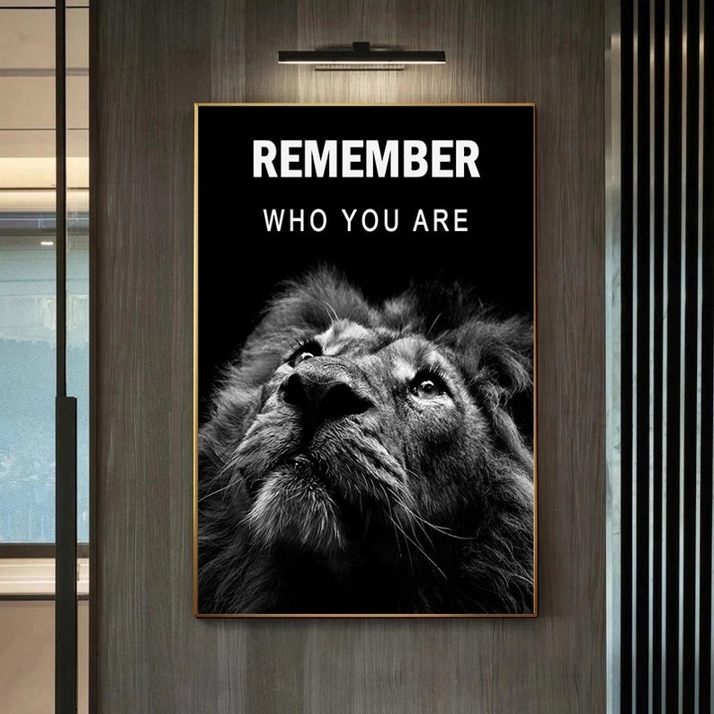 May include: Black and white motivational poster featuring a lion looking up with the text "REMEMBER WHO YOU ARE" in white.