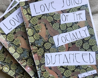 May include: A stack of three small, white paperbound books with a green, brown, and orange illustrated cover. The cover features the text "Love Songs of the Socially Distanced" and "Tim Train".