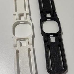 May include: Two 3D printed watch bands, one white and one black, with a cutout for a watch face.