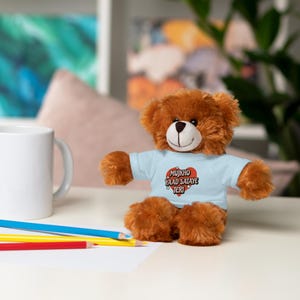 May include: A brown teddy bear wearing a light blue t-shirt with a red heart and the text "Mujhko Yaad Sataye Teri" in Hindi.