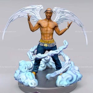 May include: A figurine of a man with angel wings, wearing a gold belt, blue jeans, and a head band. The figure is standing on a cloud-like base. The wings are white and the figure has a dark complexion.