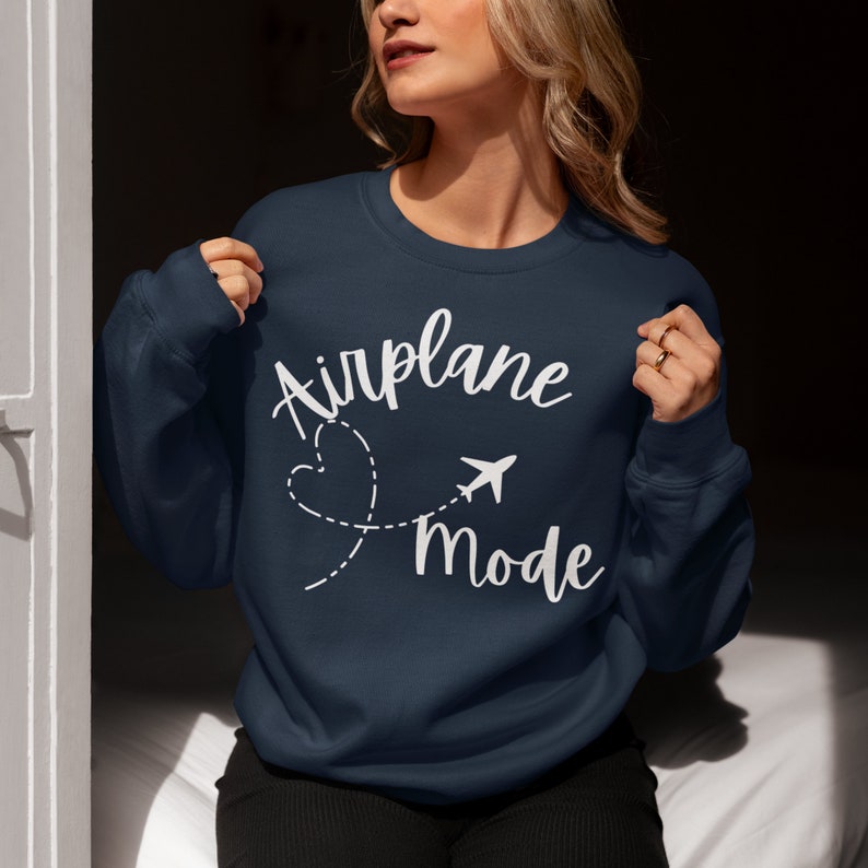 May include: A navy blue sweatshirt with the text "Airplane Mode" in white lettering. A white airplane icon and a heart shape are also included in the design.