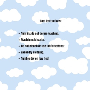 May include: A light blue background with a repeating white cloud pattern featuring black text that reads: Care Instructions: Turn inside out before washing. Wash in cold water. Do not bleach or use fabric softener. Avoid dry cleaning. Tumble dry on low heat.