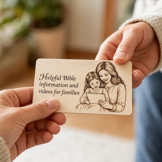 Kindred Light Family Contact Card being passed between two people in a close-up indoor scene.