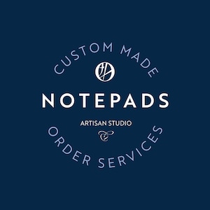 May include: A blue and white logo for a business that makes custom notepads. The logo says "Custom Made Notepads Artisan Studio Order Services".