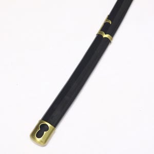 A close-up of the black katana scabbard, showing a gold cap at the end and gold accents along its length.