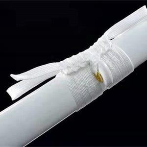 Close-up of a white katana scabbard with a white cord wrapped around it, secured by a small gold-colored ring.