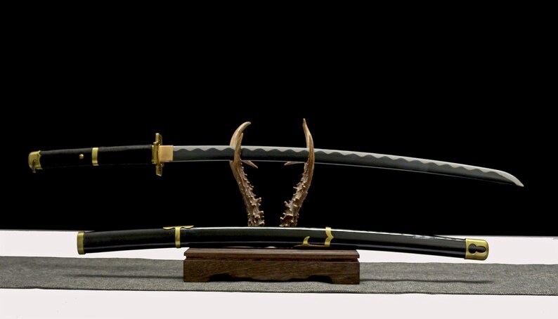 A black and gold katana with a silver blade rests on an antler-like stand, with its matching scabbard below.