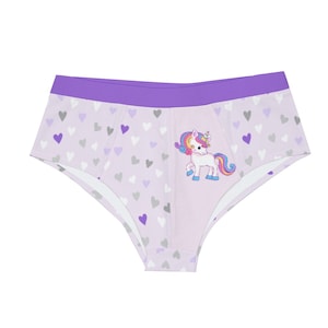 May include: Light purple underwear with a purple waistband and a pattern of hearts in gray, white, and purple. A cartoon unicorn with a rainbow mane and tail is on the front. The underwear is made of a soft material.