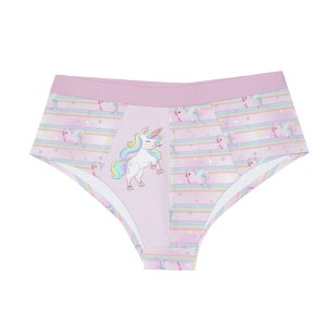 May include: Pink underwear with a unicorn design. The underwear has a light pink waistband and a central panel with a unicorn illustration. The sides feature a striped pattern with unicorns and stars in pastel colours.