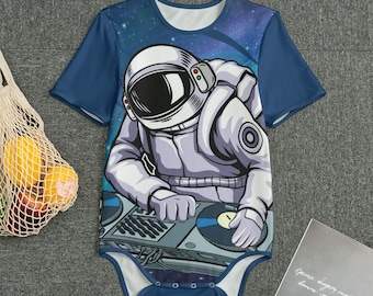 Könnte beinhalten: Ein blauer Baby-Body mit einer Grafik eines Astronauten, der im Weltraum als DJ arbeitet. Der Astronaut trägt einen weißen Raumanzug und Helm. Der Hintergrund hat ein Sternenhimmel-Design. Der Body hat kurze Ärmel und einen runden Ausschnitt.