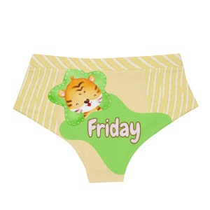 May include: Yellow and cream-colored underwear with a cartoon tiger illustration. The underwear features a green shape with the word "Friday" and a striped pattern on the waistband.